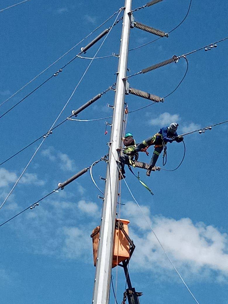 Hopolang lineworkers on a high-voltage transmission pole
