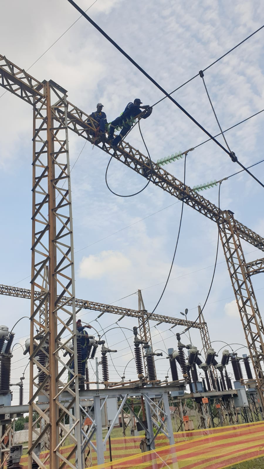 Crew on a steel lattice beam during HV maintenance