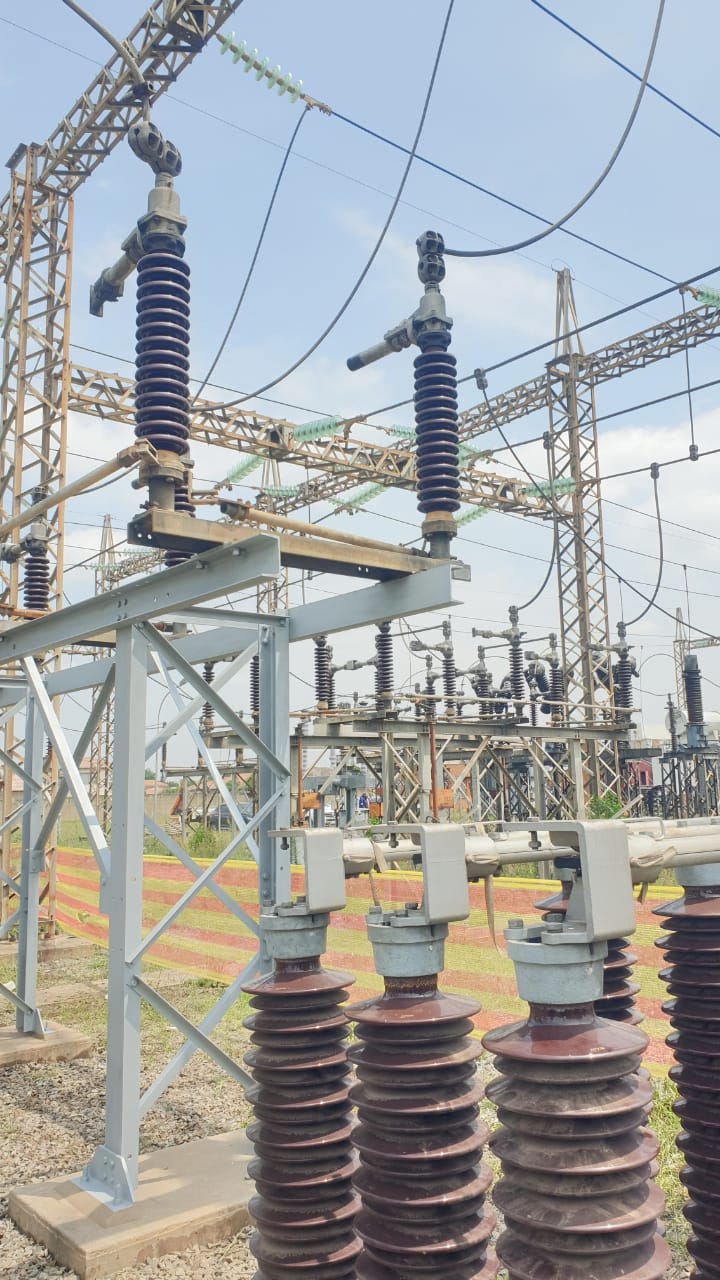 Two technicians on a substation gantry beam